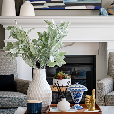 colorful living room decor with patterned chairs and fireplace Design by Aman Than Interiors and Photography by Mike Chajecki